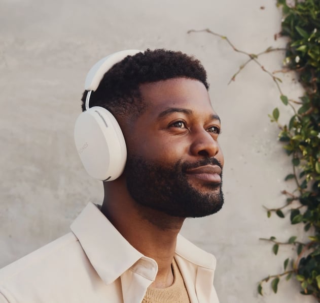 Man looking into distance with satisfied expression enjoying music through custom branded headphones