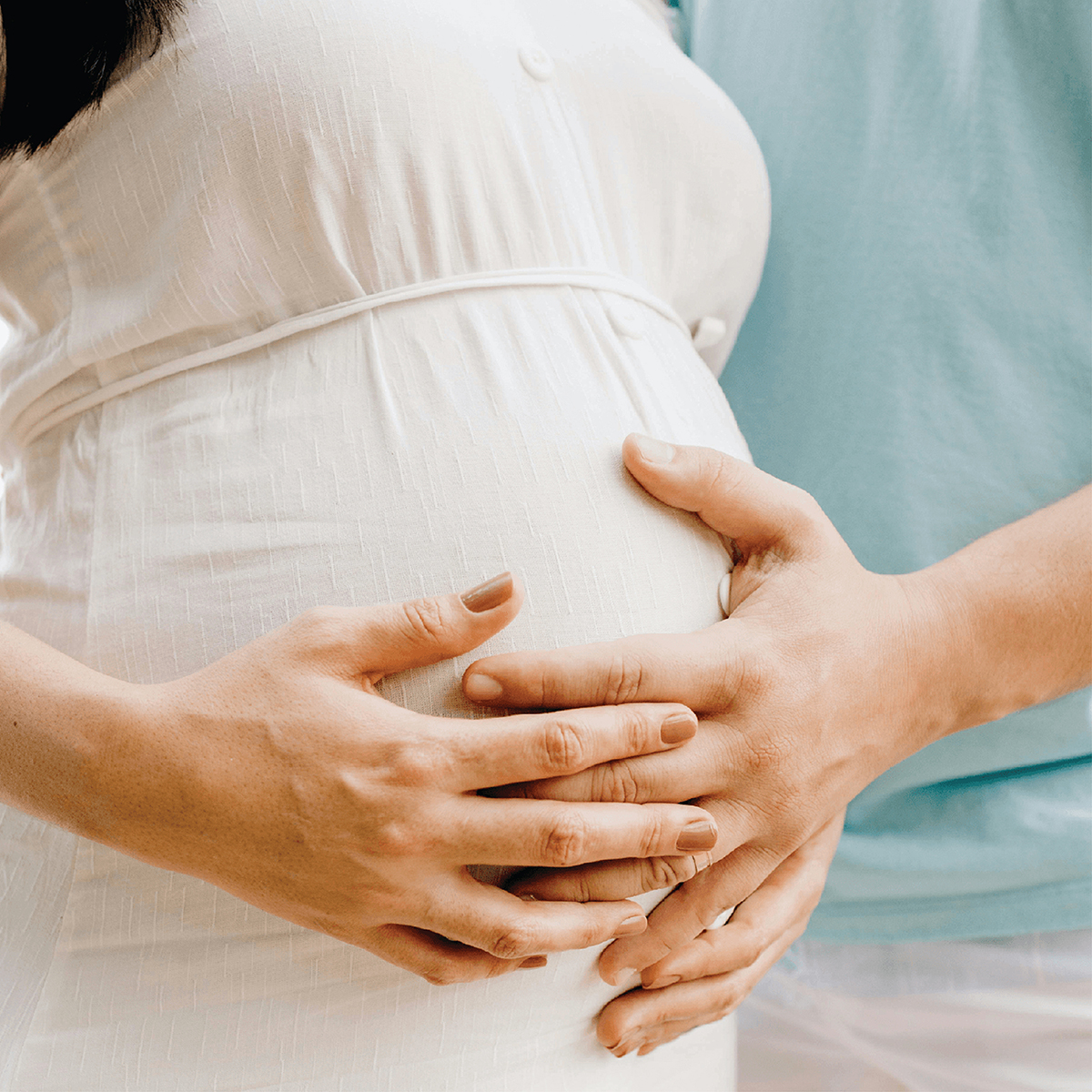 Woman with pregnant belly, hand on belly 
